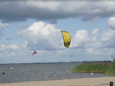 Kitesurfer kan harde wind niet aan; kite in boom